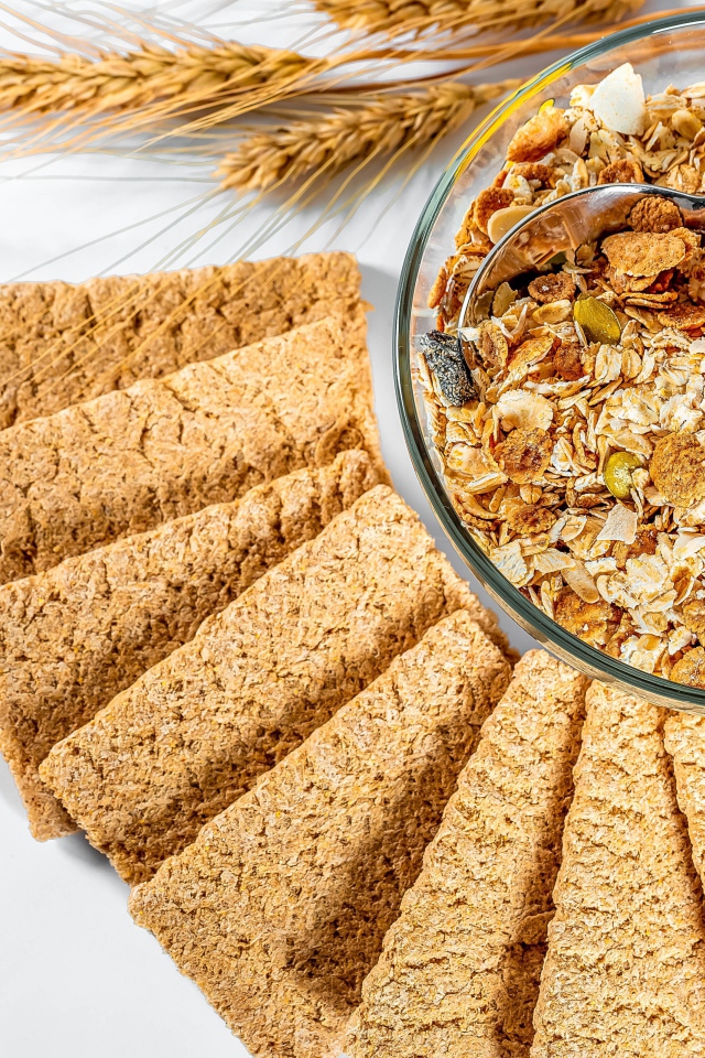 Мюсли в тарелке на столе с хлебцами 