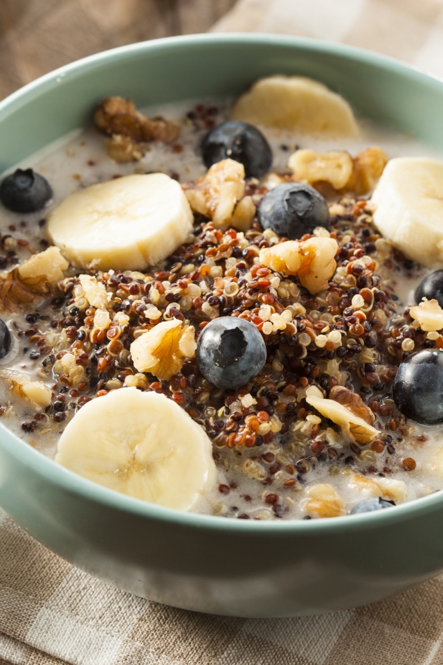 Мюсли с молоком в тарелке с ягодами черники и бананами