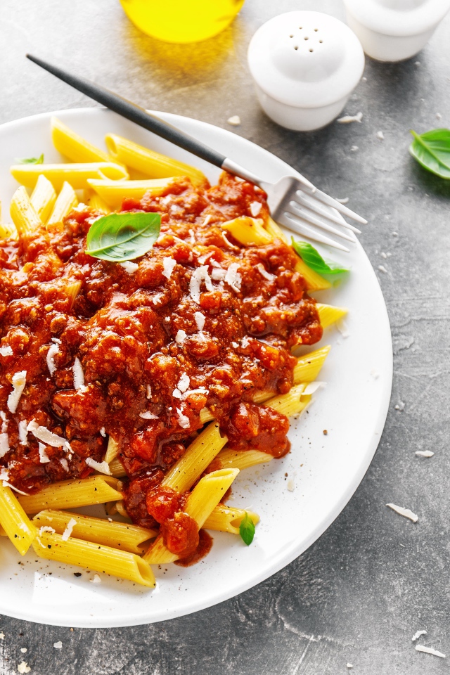 Макароны с соусом на белой тарелке