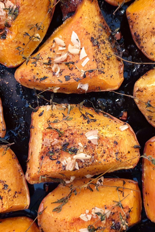 Куски жареной тыквы со специями на сковороде 