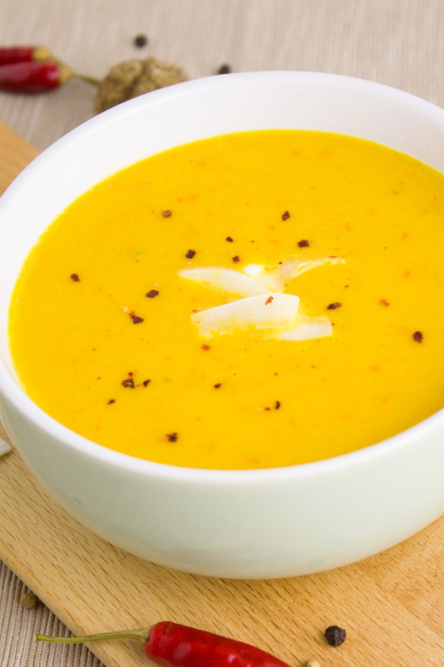 Тыквенный суп пюре на доске в белой тарелке 