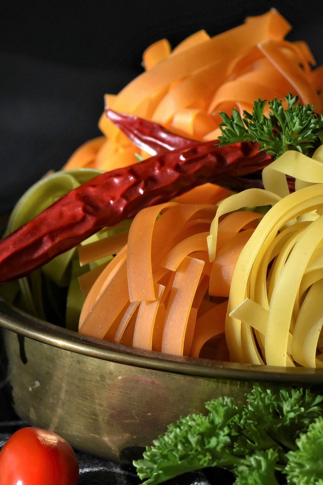 Сырая лапша на столе с острым перцем и петрушкой