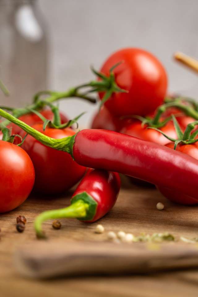 Красный острый перец с помидорами на столе