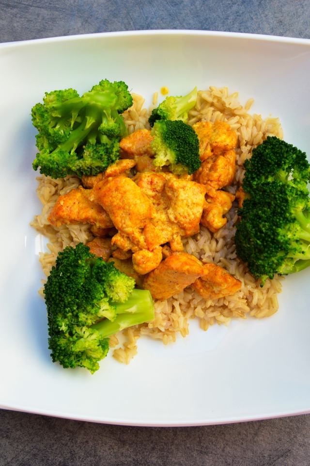Rice with meat and broccoli in a white plate
