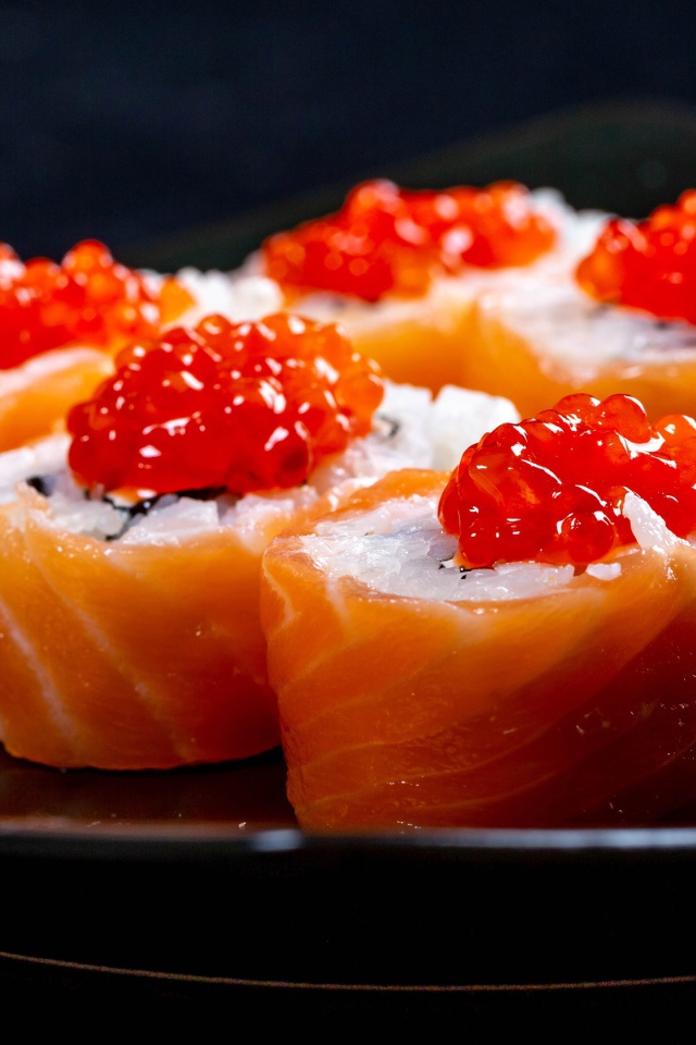 Роллы с красной рыбой и икрой на тарелке