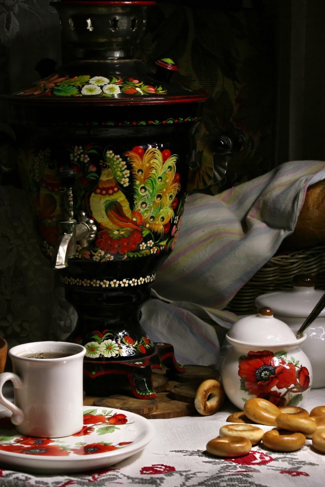 Самовар стоит на столе с чаем и баранками