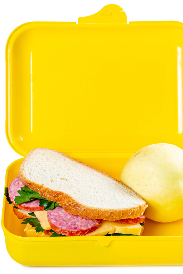 Бутерброд и яблоко в контейнере на белом фоне