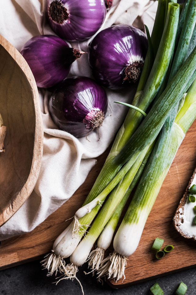 Бутерброд на столе с зеленым и репчатым луком