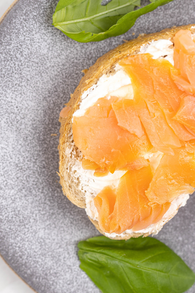 Бутерброд с сыром, красной рыбой и листьями базилика