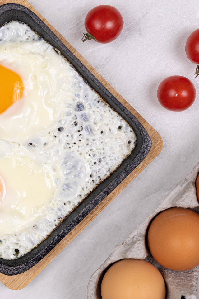 Яичница с помидорами и яйцами на столе