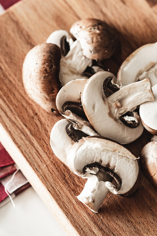 Нарезанные шампиньоны на разделочной доске