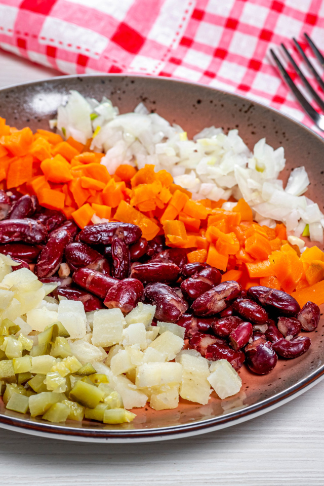 Овощи и фасоль нарезанные на тарелке 