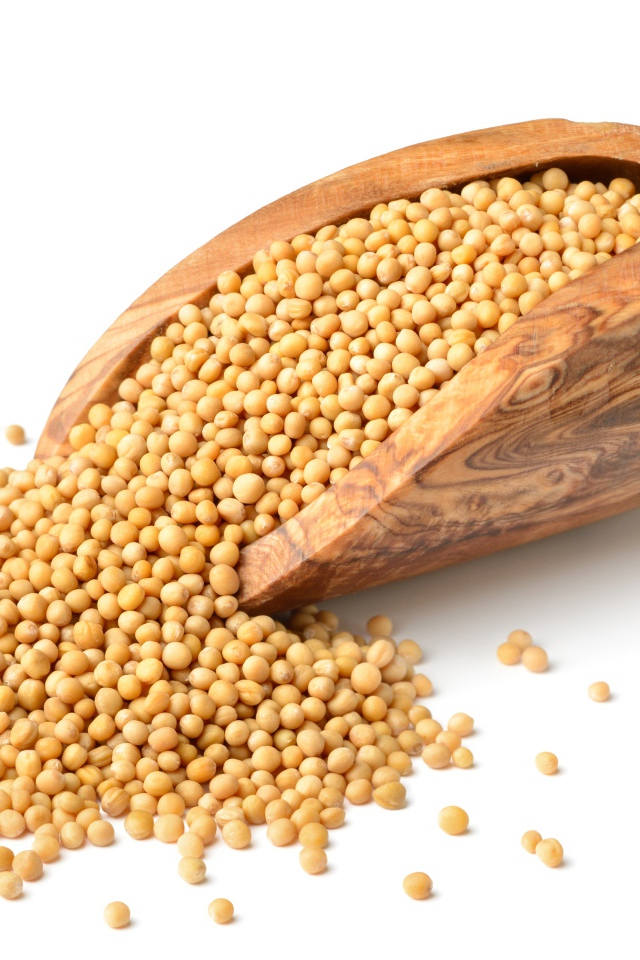 Мелкий горох в деревянном совке на белом фоне