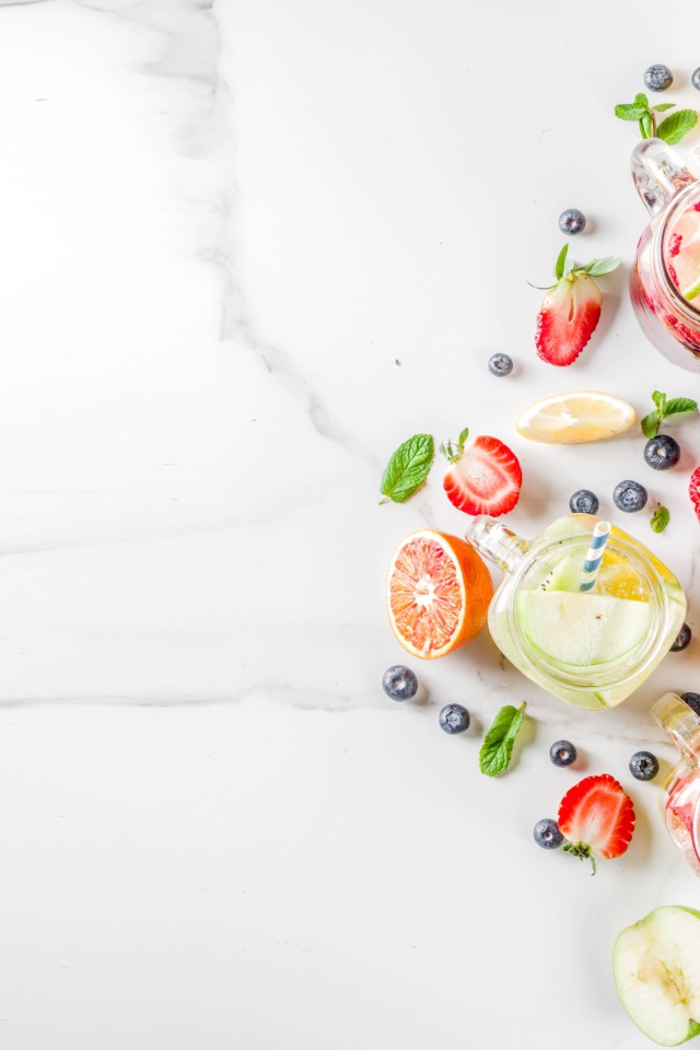 Смузи в баночках на столе с ягодами и фруктами