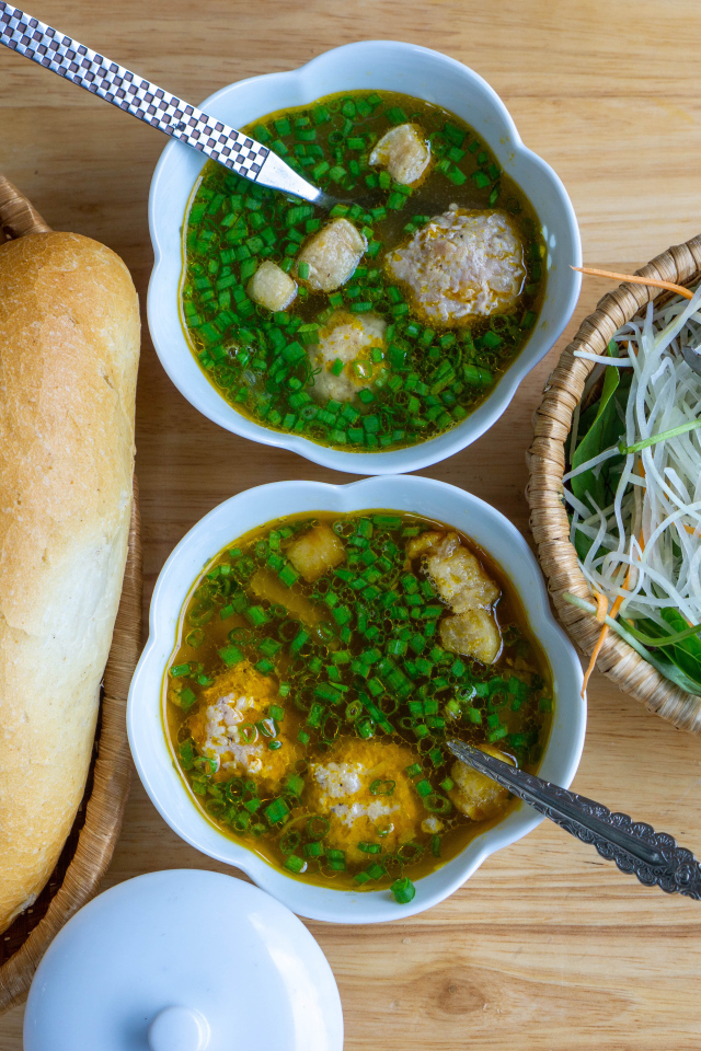 Суп с фрикадельками на столе с хлебом и салатом 