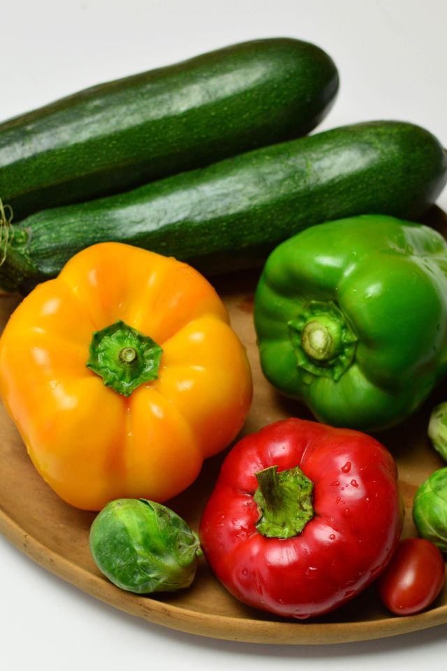 Сладкий перец, кабачки, помидоры и брюссельская капуста на сером фоне