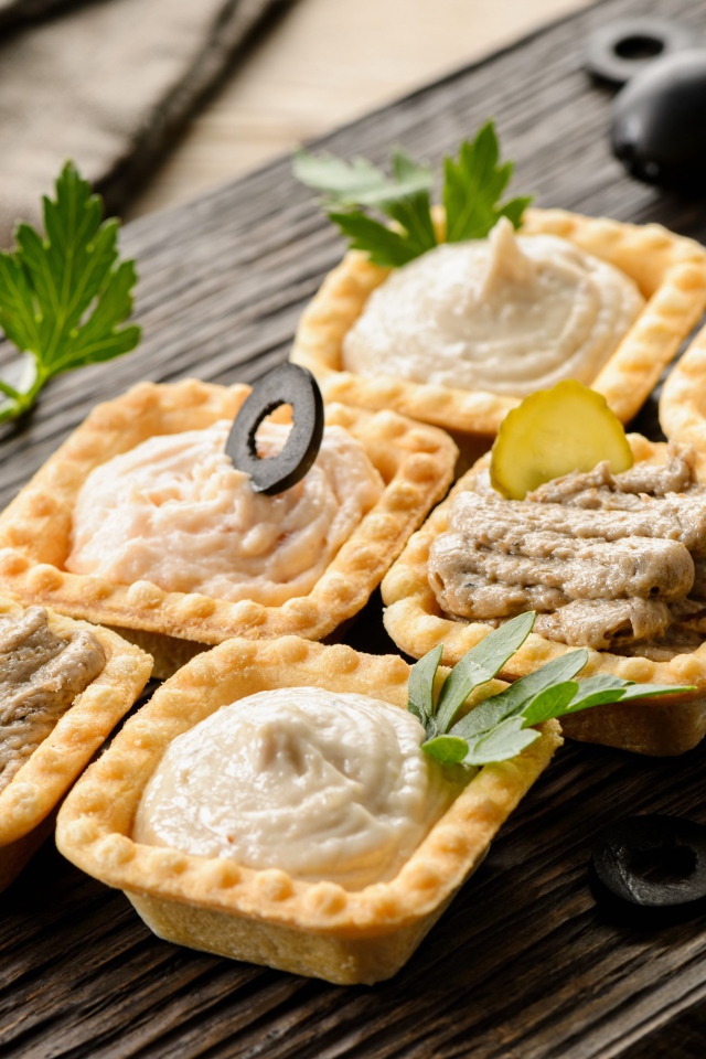 Тарталетки с паштетом на столе с оливками 