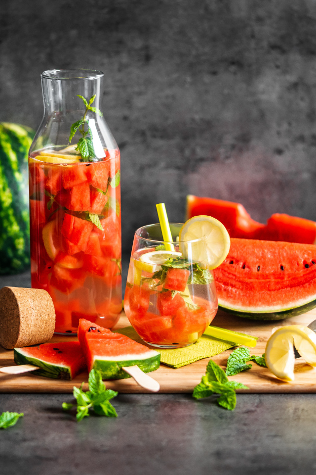 Вкусный напиток на столе с кусочками арбуза 