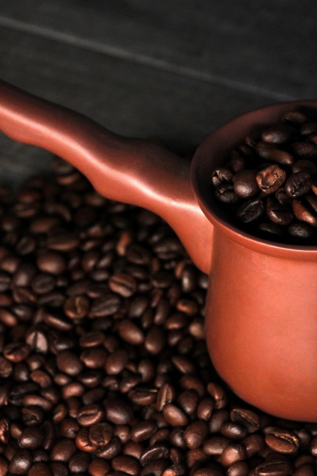 Турка с кофейными зернами на столе 