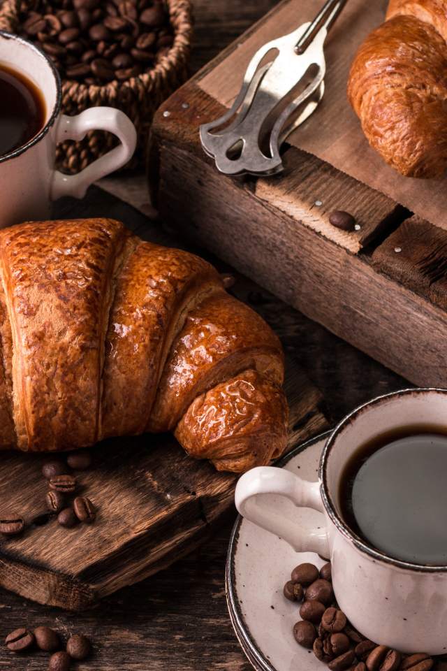 Две чашки кофе на столе с рогаликами и зернами 