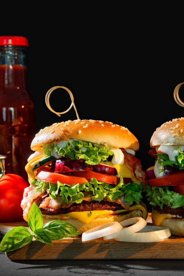 Два гамбургера на столе с картофелем фри, кетчупом и помидорами