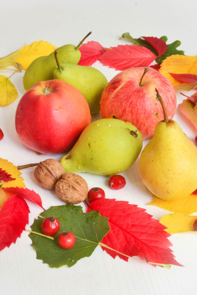 Яблоки и груши с опавшими листьями на белом фоне
