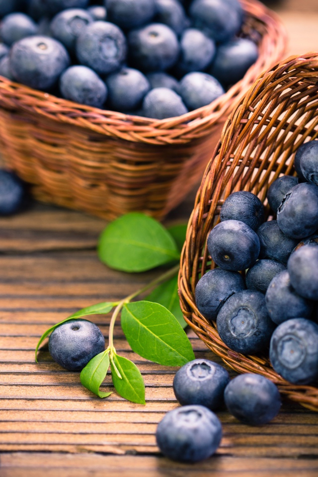 Синие ягоды черники в корзинках на столе 