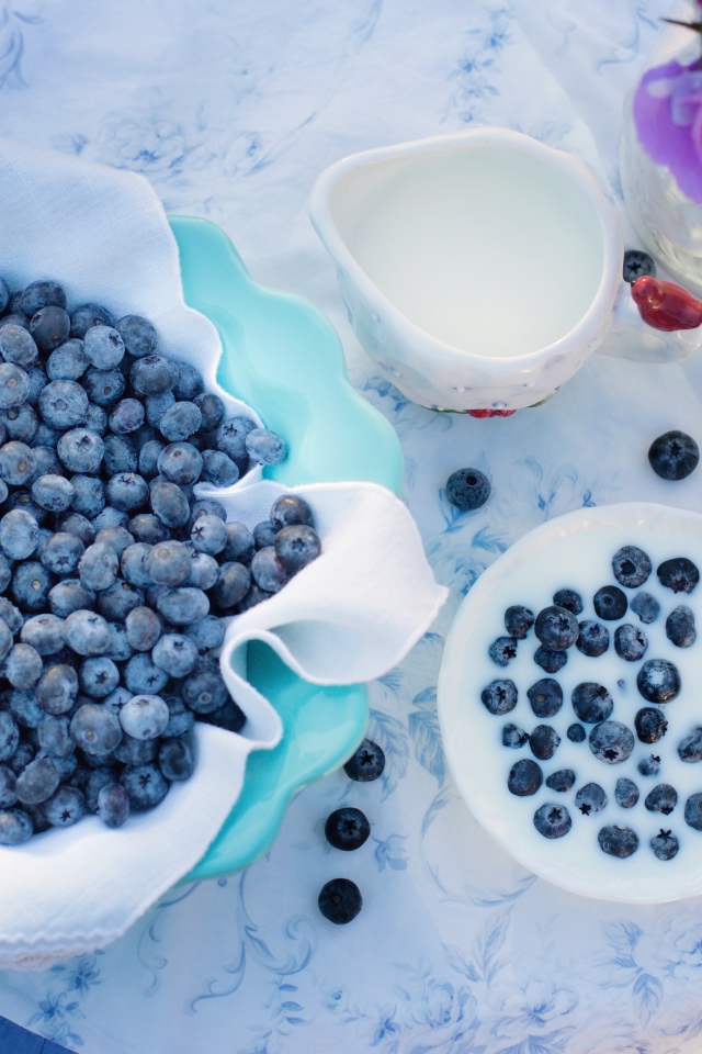 Синие ягоды черники на столе с молоком 