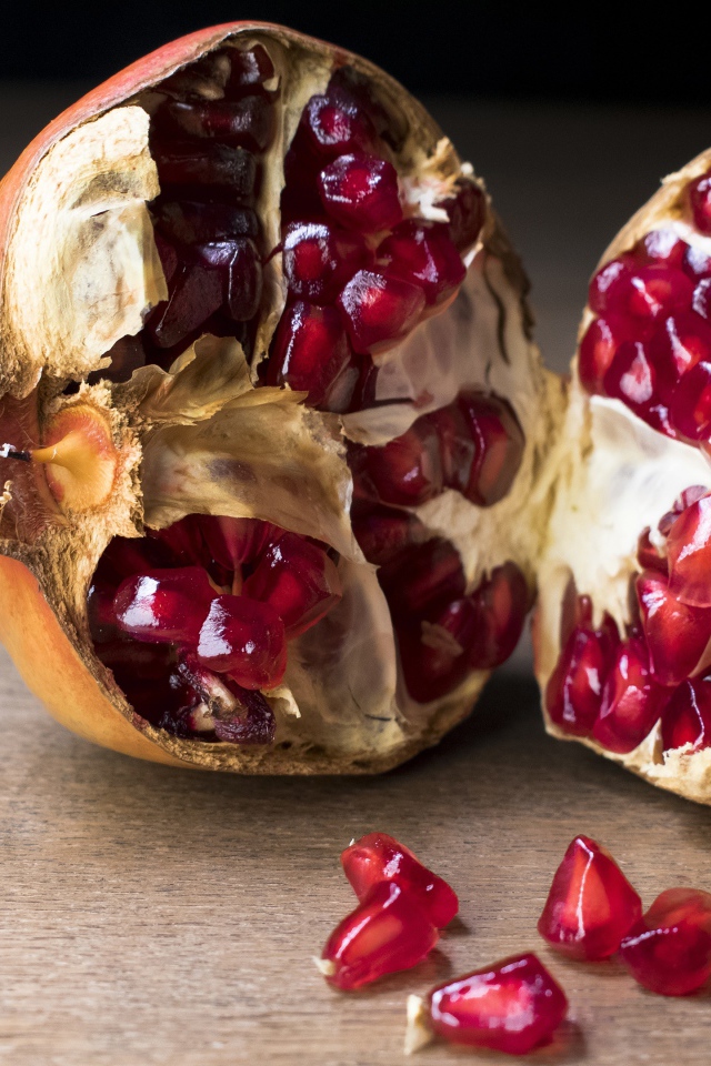 Разломанный красный гранат на столе 