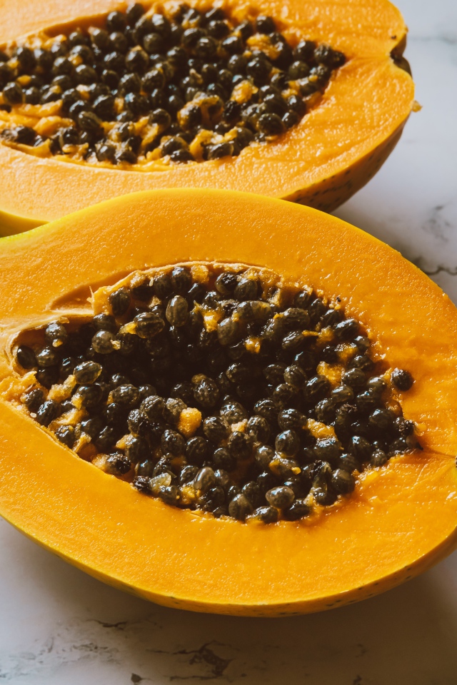 Разрезанный плод папайи на столе 