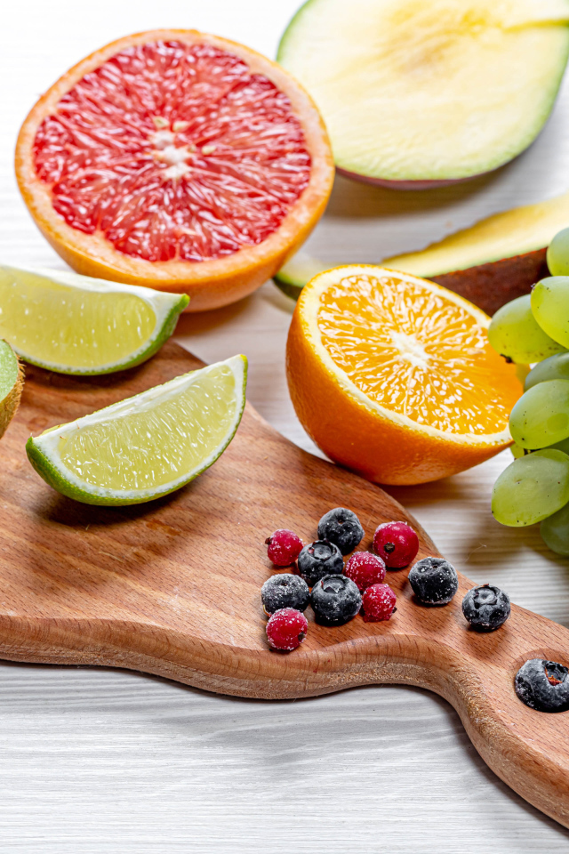 Вкусные цитрусовые фрукты и виноград на столе