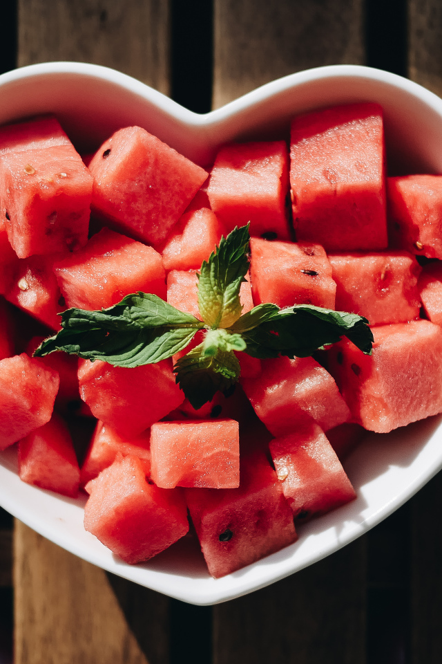 Нарезанный кубиками арбуз в белой тарелке в форме сердца