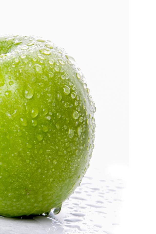 Зеленое яблоко в воде на белом фоне