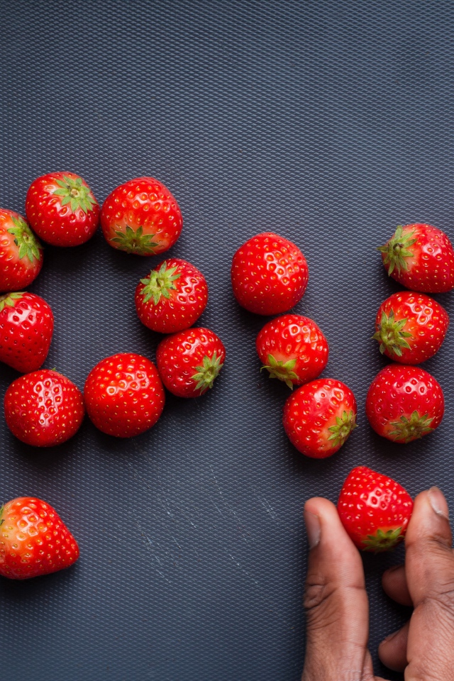 Надпись LOVE выложена из ягод спелой клубники 