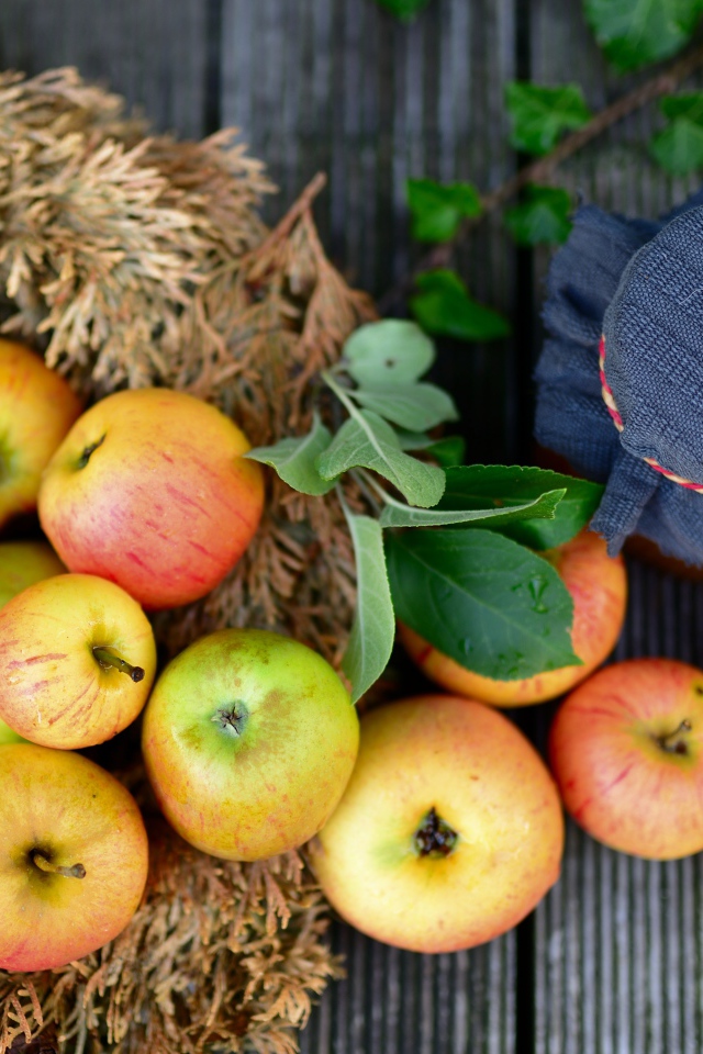 Много спелых яблок на столе с вареньем 