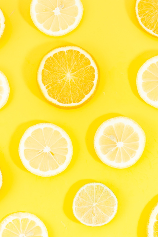 Кружочки апельсина и лимона на желтом фоне