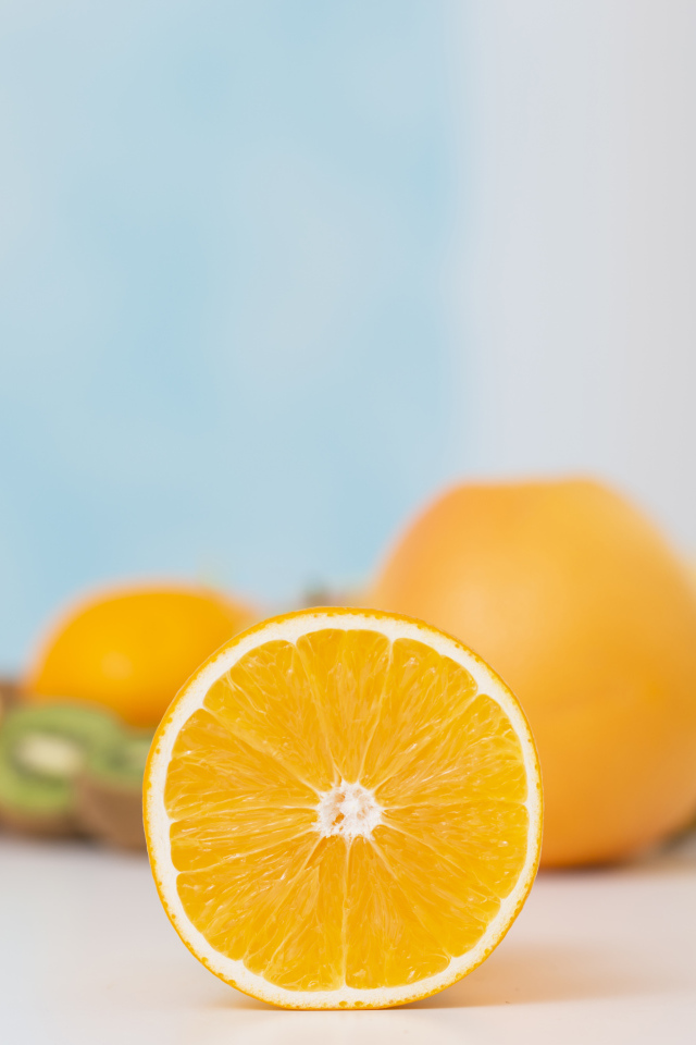 Оранжевые апельсины с киви на столе 