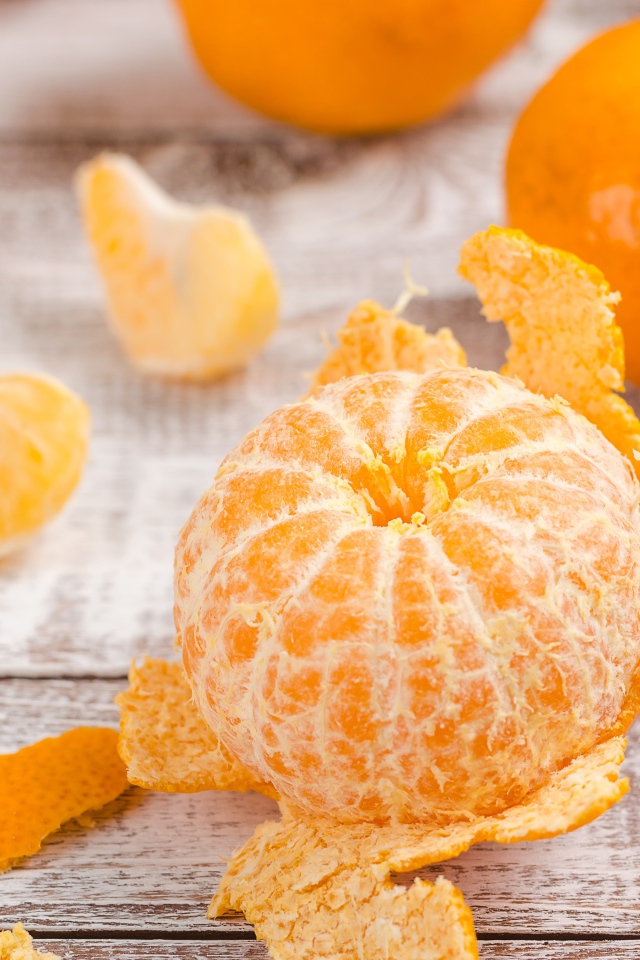 Очищенный мандарин на деревянном столе 