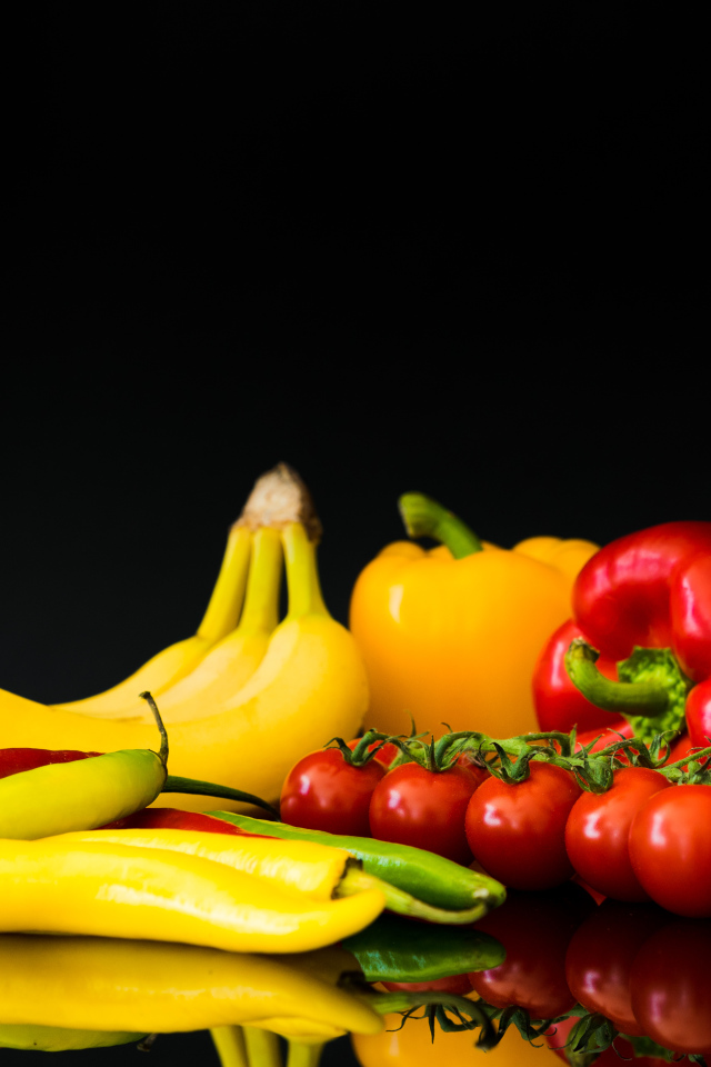 Перец, помидоры и бананы на черном фоне