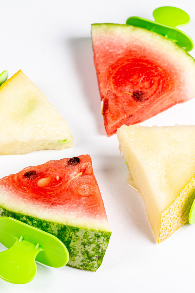 Кусочки арбуза и дыни на палочках на белом фоне