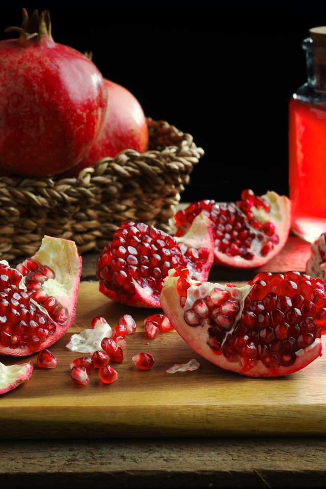 Плоды граната на столе с соком 