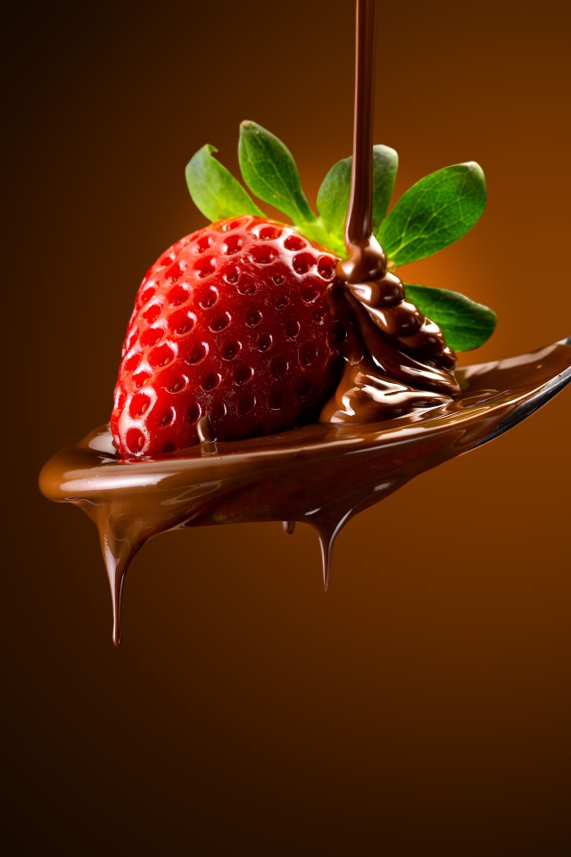 Красная клубника на ложке с молочным шоколадом