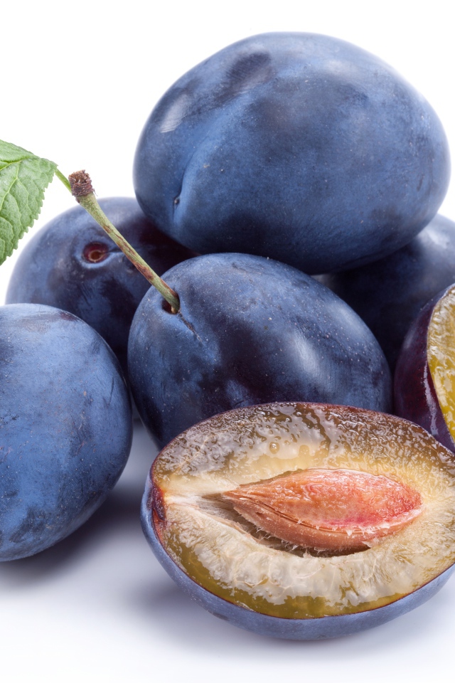 Спелые синие сливы на белом фоне