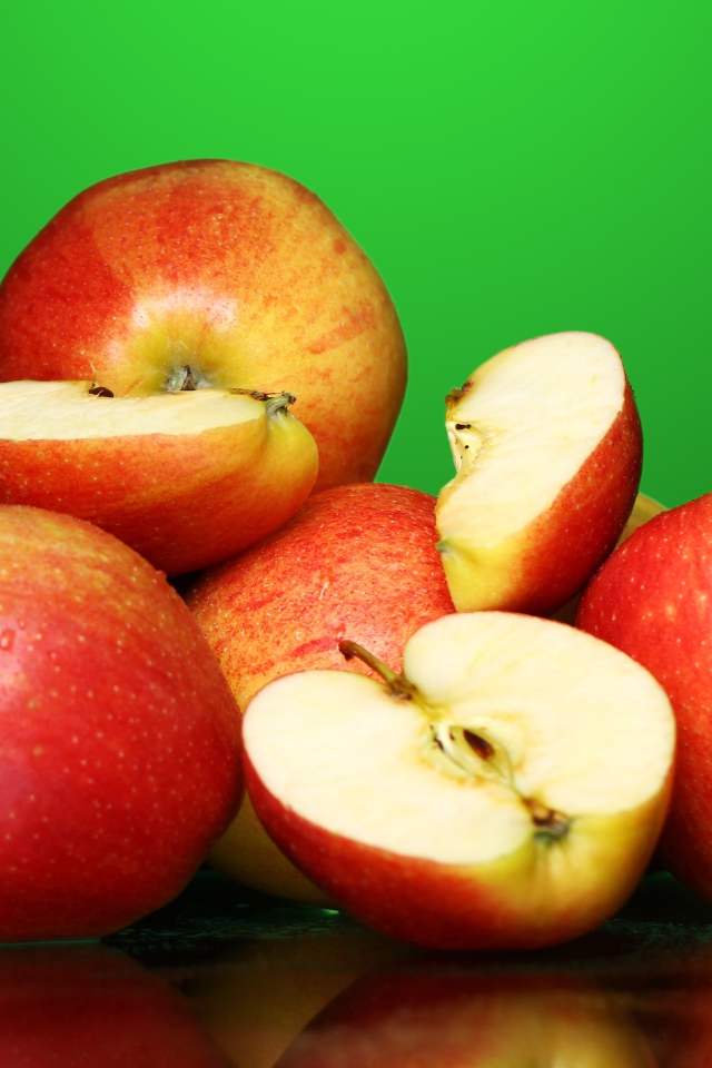 Спелые вкусные красные яблоки на зеленом фоне
