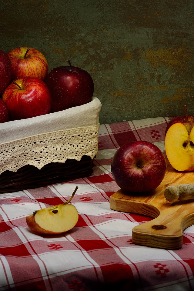 Спелые красные яблоки на столе с ножом