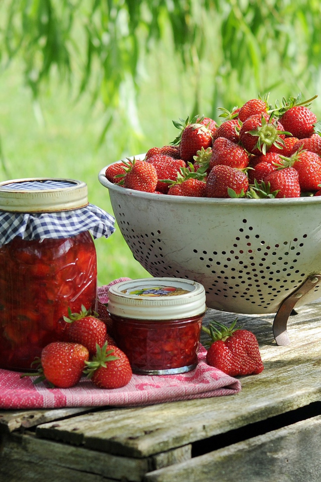 Ripe red strawberries with jam stand on a box
