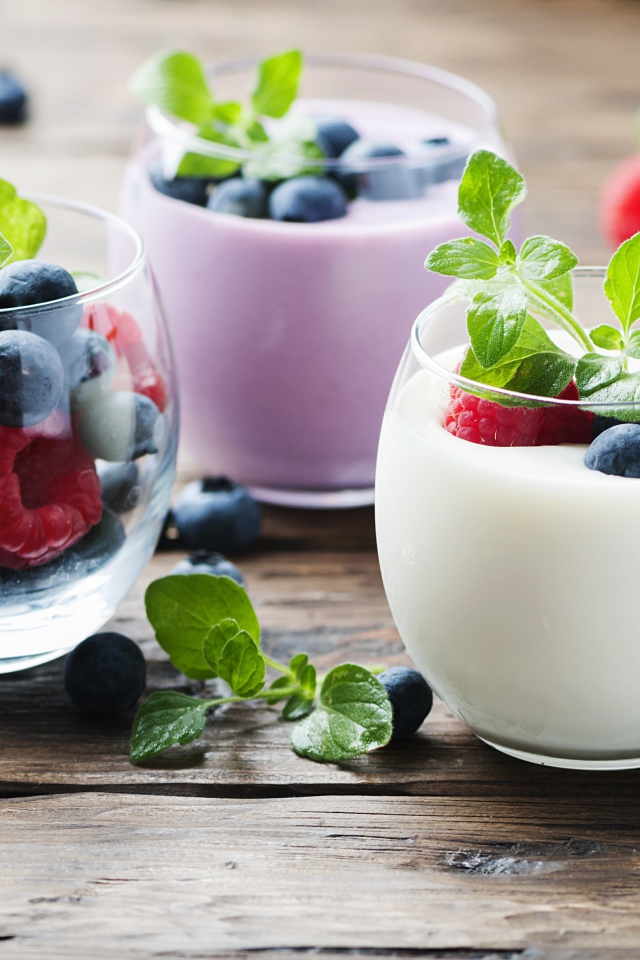 Вкусный йогурт с ягодами черники и малины на столе 