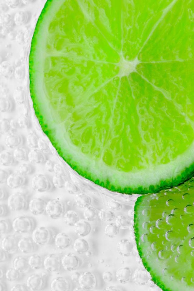 Два куска лайма в пузырях в воде 
