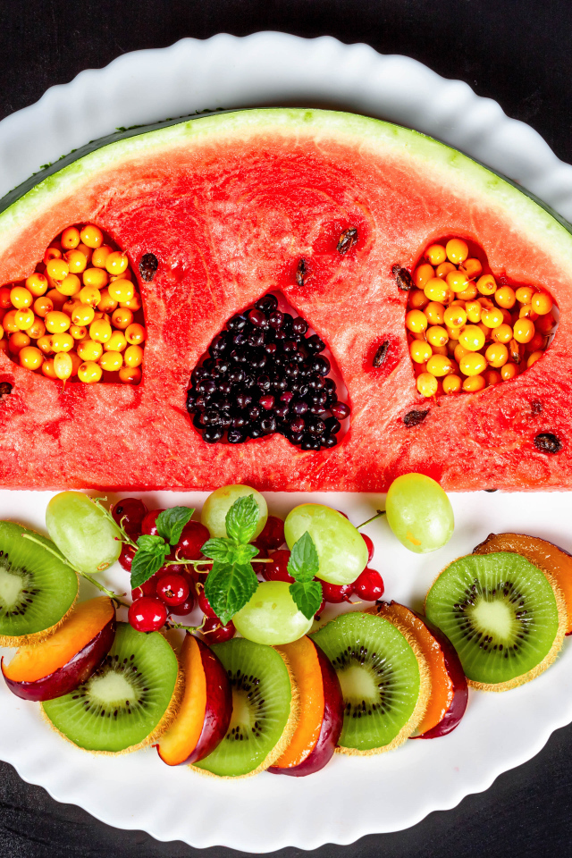 Арбуз на тарелке с ягодами 