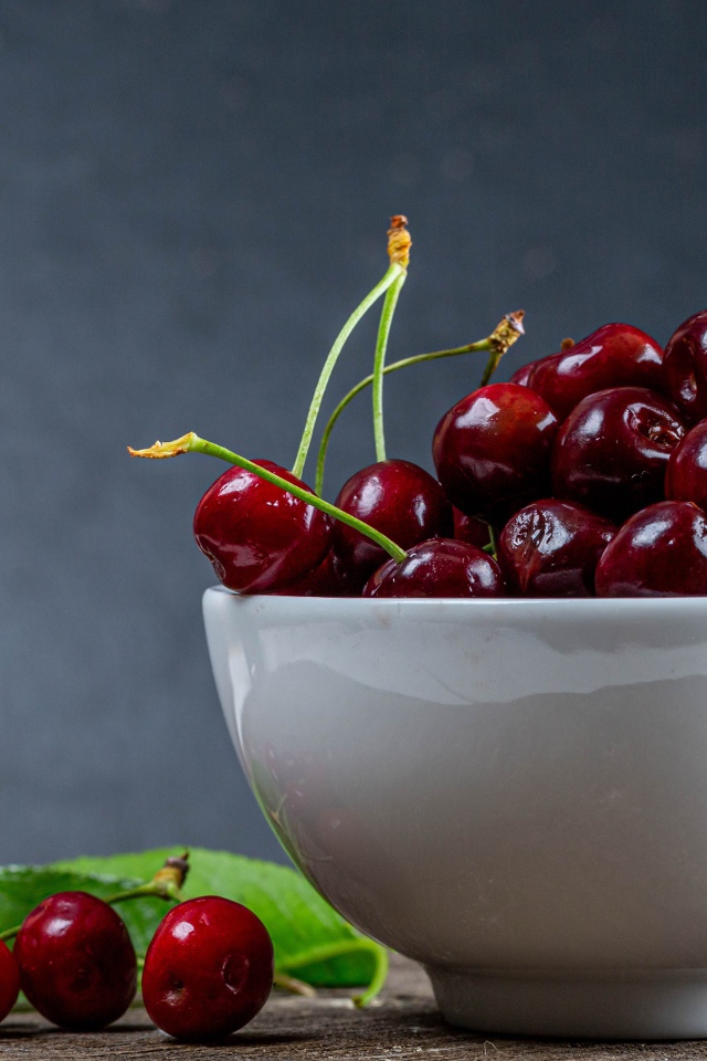 Белая фарфоровая тарелка с красной спелой черешней 